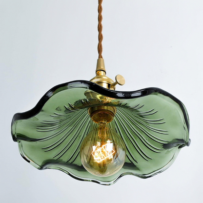 Green glass pendant light with a gold bulb on a white background