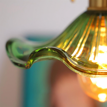 Close-up of a green glass light fixture with a blurred background