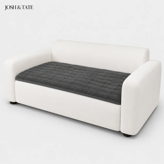 Josh & Tate - FluffLayer™ Plush Sofa Pad - White sofa with a gray quilted cushion on a white background, featuring the brand 'Josh & Tate'.