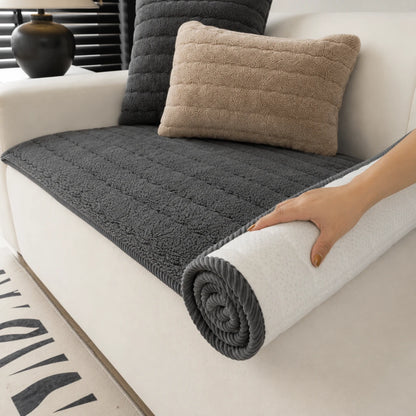 Josh & Tate - FluffLayer™ Plush Sofa Pad - Person unrolling a gray textured blanket on a white couch with pillows.