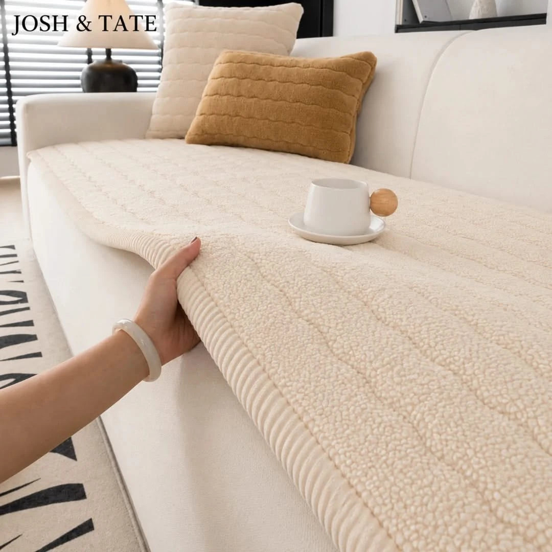 Josh & Tate - FluffLayer™ Plush Sofa Pad - Person holding a textured beige throw blanket on a sofa with 'JOSH & TATE' branding.