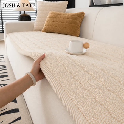 Josh & Tate - FluffLayer™ Plush Sofa Pad - Person holding a textured beige throw blanket on a sofa with 'JOSH & TATE' branding.