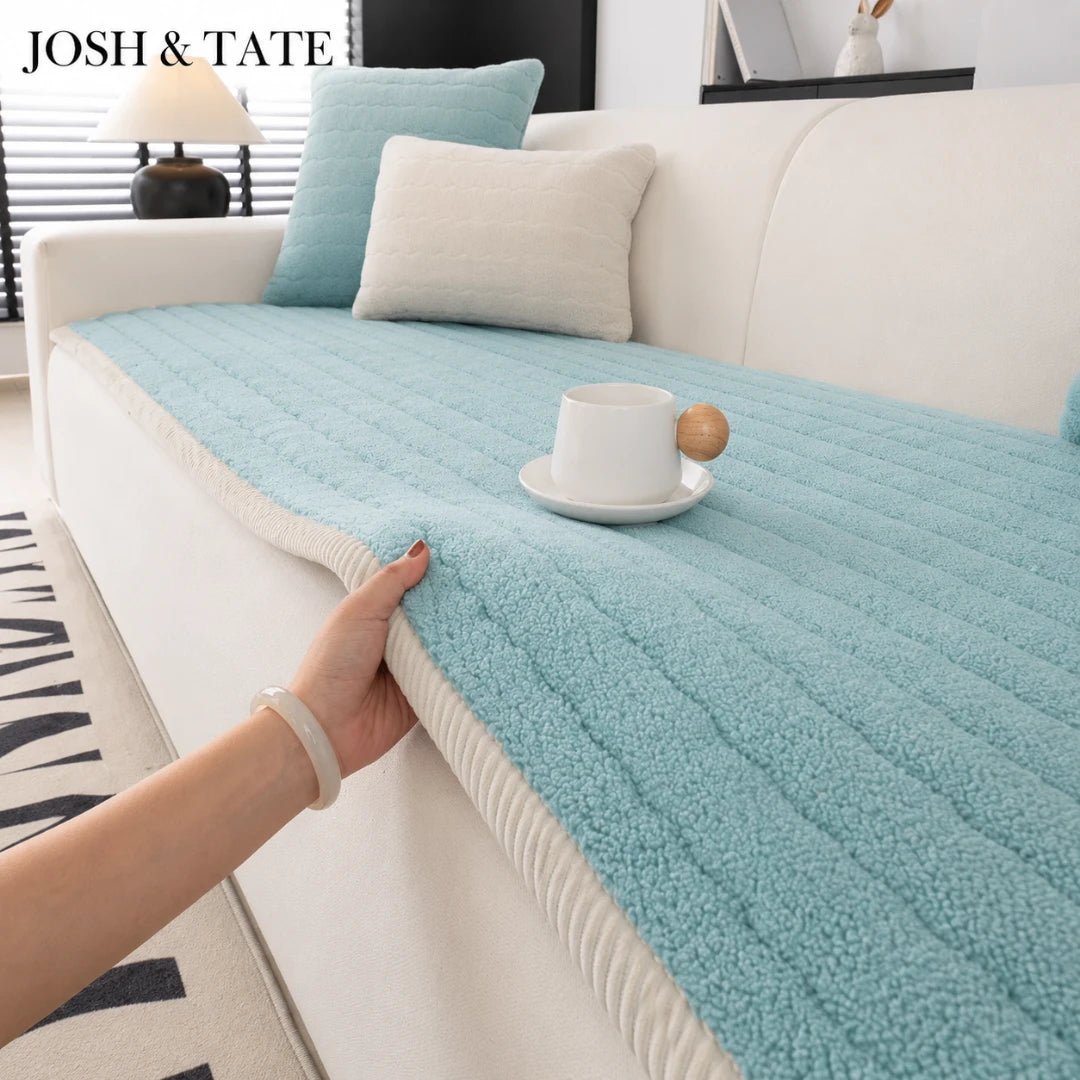 Josh & Tate - FluffLayer™ Plush Sofa Pad - Light blue sofa cover being held by a hand on a white sofa with decorative pillows.