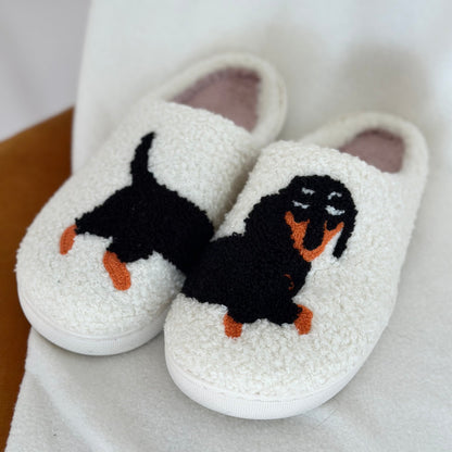 White slippers with a black and orange dog design on a white background