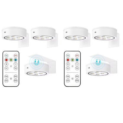 Set of six white undercabinet lights with remote controls on a white background