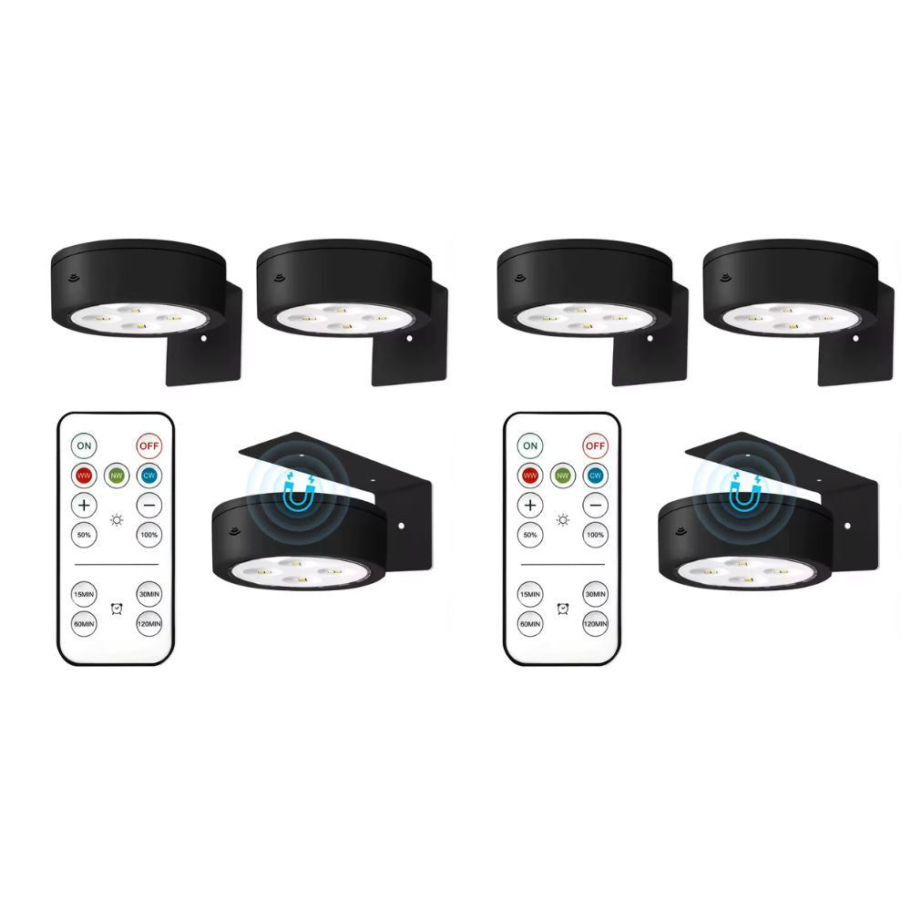Set of four black outdoor wall lights with remote controls on a white background