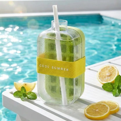 Josh & Tate - FrostPour™ 2-in-1 Ice Cube Tray & Drinking Bottle - Glass bottle with green drink, lemon slices, and mint leaves by a poolside.