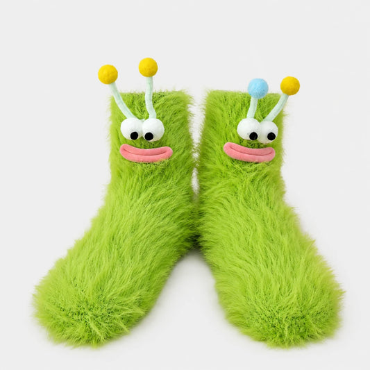 Josh & Tate - FuzzBuddy™ Cozy Socks - A pair of bright lime green fuzzy socks shaped like cartoon alien feet, with white embroidered eyes, pink stitched mouths, and antennae topped with yellow and blue balls, shown on a light gray background.