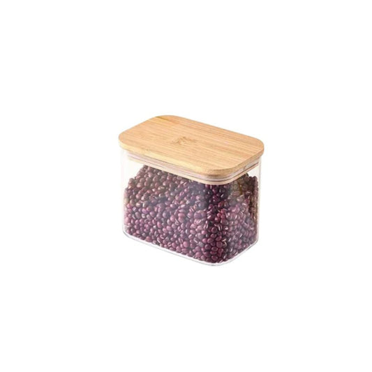 Glass storage container with a wooden lid filled with black beans on a white background