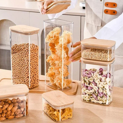 Glass storage containers with wooden lids on a kitchen counter.