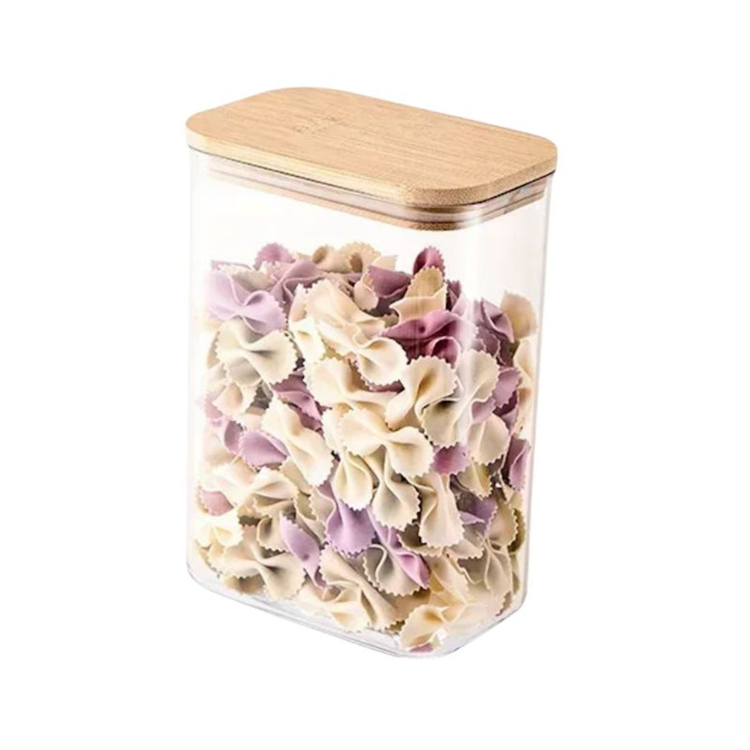 Clear container with wooden lid filled with bow-tie pasta on a white background