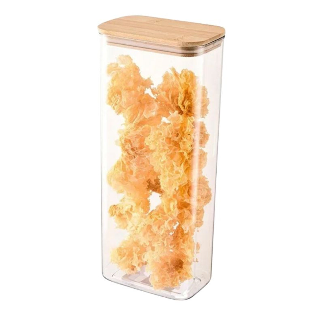 Clear storage container with wooden lid filled with orange snacks on a white background