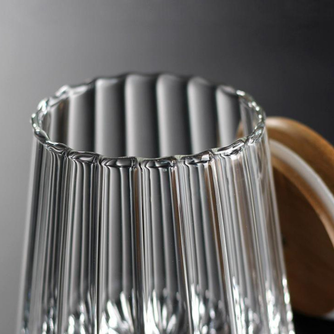 Clear glass vase with ribbed design on a dark background