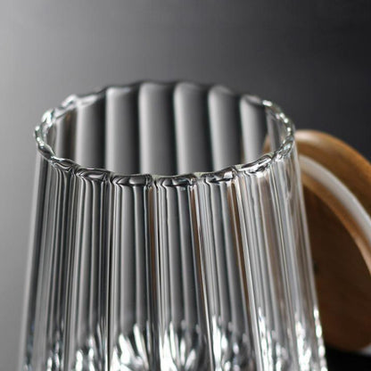 Clear glass vase with ribbed design on a dark background