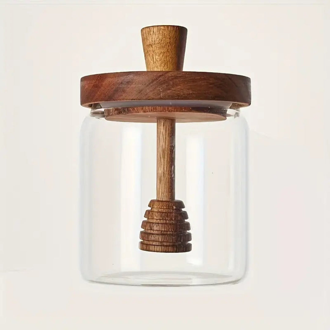 Glass jar with wooden lid and handle on a light background