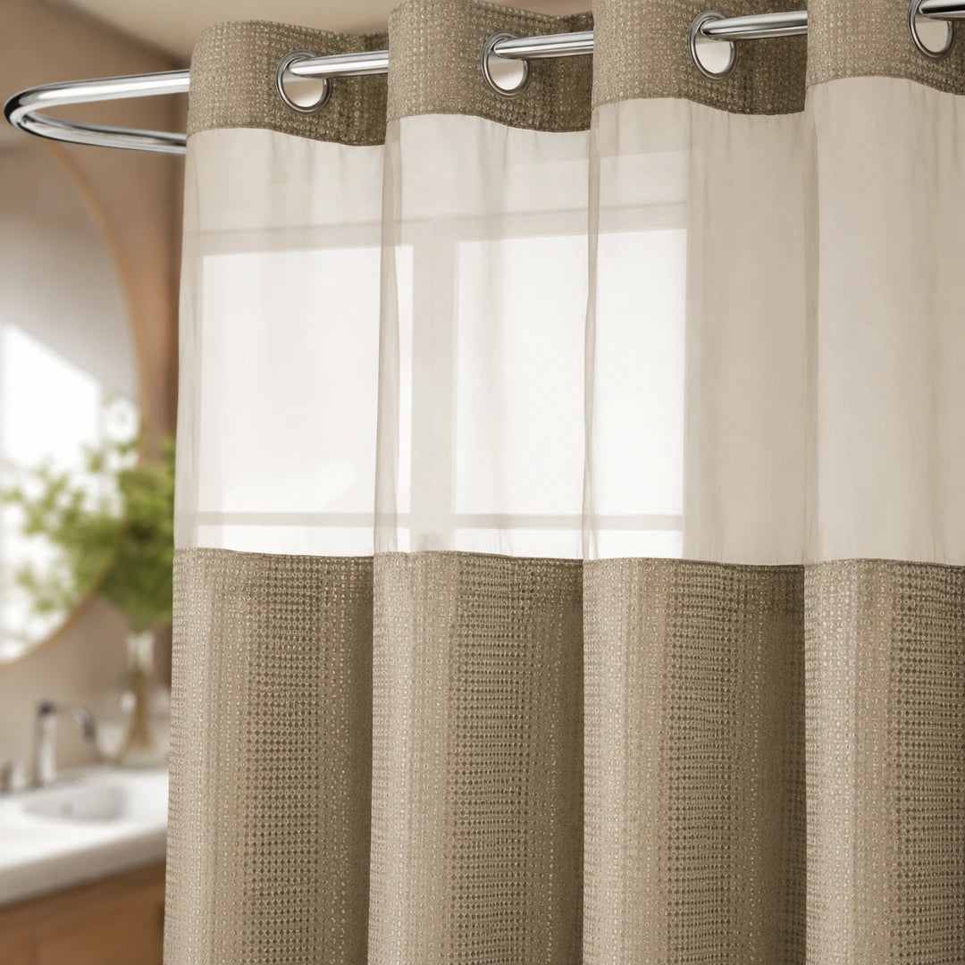 Josh & Tate - GlideCurtain™ No-Hook Shower Curtain - A two-tone window curtain panel hanging on a silver rod, with a textured beige lower section and a sheer off-white upper section, shown in a softly blurred bathroom setting.