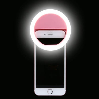Smartphone with a pink ring light attachment on a black background