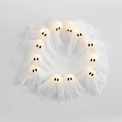 Decorative wreath with ghost-shaped lights on a white background