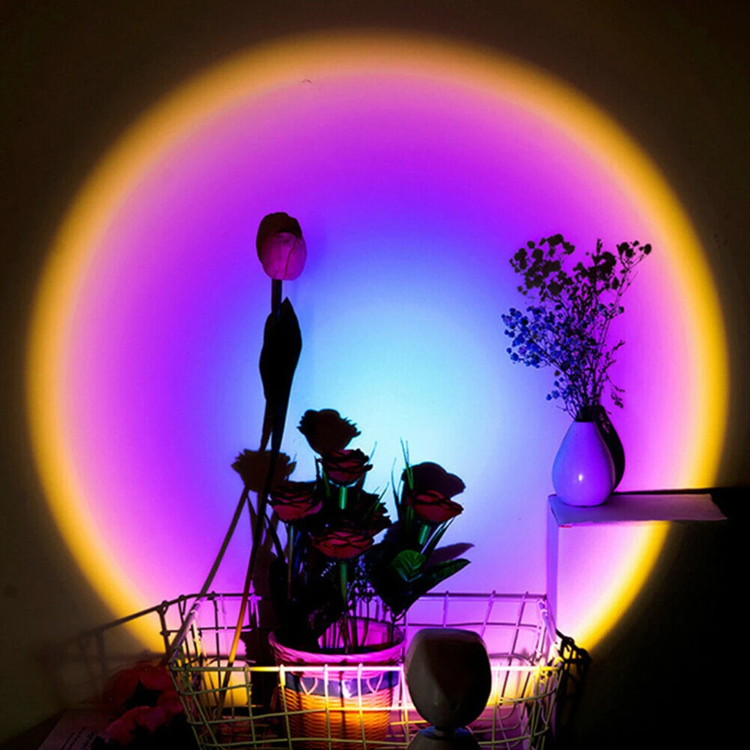 Josh & Tate - GoldenHour Sunset Lamp - Decorative setup with flowers, a vase, and a lamp against a colorful circular light projection.