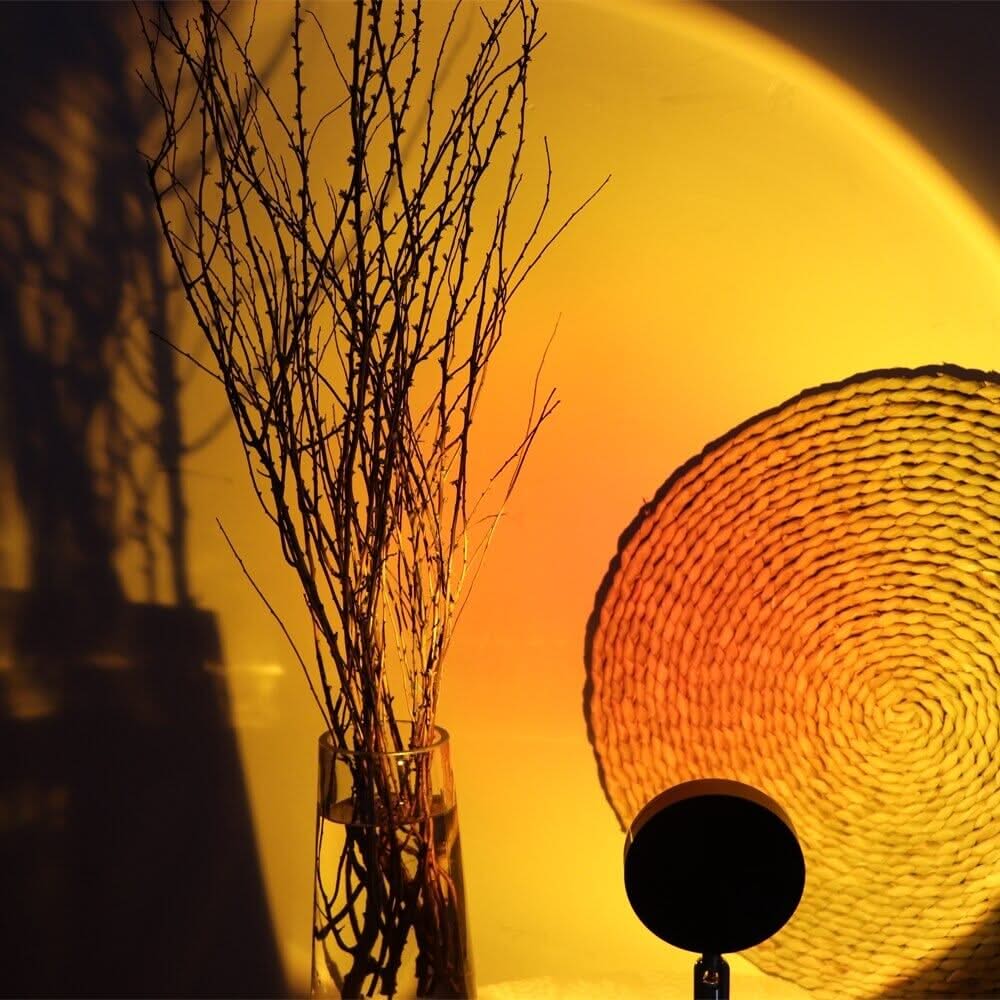 Vase with branches and woven wall art against a warm yellow background