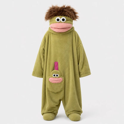Josh & Tate - GoofSuit™ Big Mouth Monster Onesie - A plush monster costume jumpsuit in olive green with a brown furry hair accessory, pink mouth details, and a smaller matching face patch on the pocket, shown against a plain light gray background.