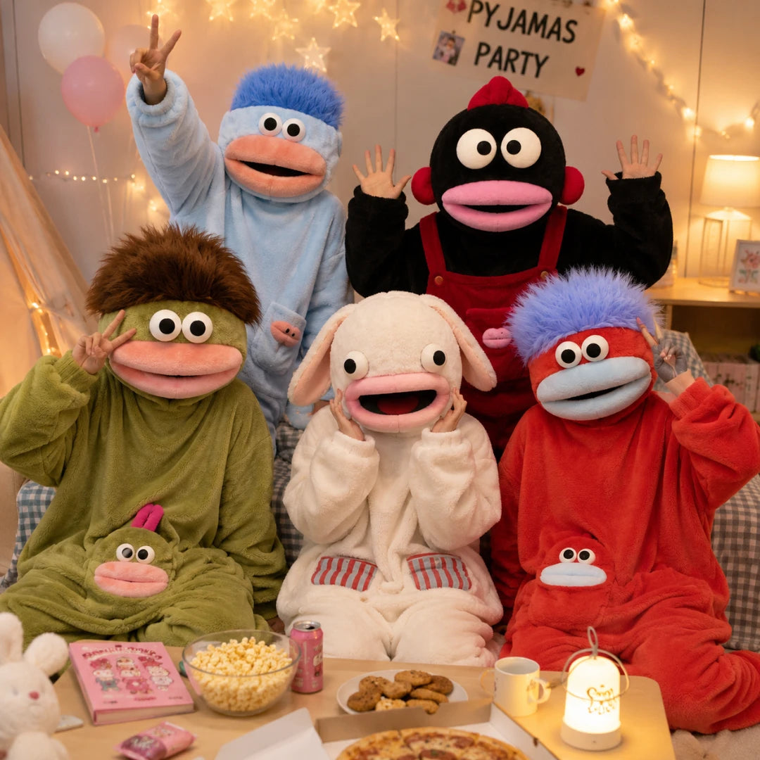 Josh & Tate - GoofSuit™ Big Mouth Monster Onesie - Five children wearing colorful plush animal pajamas pose together in a cozy room decorated with fairy lights and balloons. The pajama designs include a blue duck, a black monkey in red overalls, a green monkey, a white sheep, and a red monkey with blue hair.