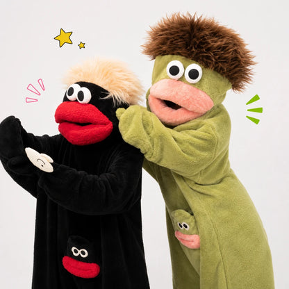 Josh & Tate - GoofSuit™ Big Mouth Monster Onesie - Two plush puppet costumes on a plain light background. One costume is black with a fluffy cream top and a red mouth, and the other is olive green with a brown hair-like texture and a pink mouth.