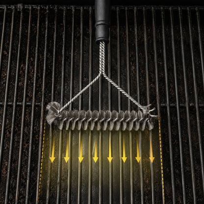 Josh & Tate - GrillBrush™ Stainless Grate Cleaner - A close-up of a stainless steel wire grill brush being pulled down over a black metal grill grate, with yellow arrows indicating downward motion and cleaning action.
