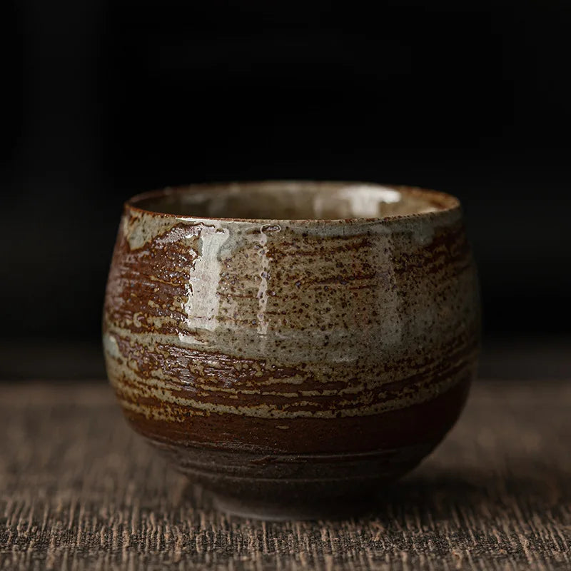 Ceramic cup with brown and beige glaze on a dark background