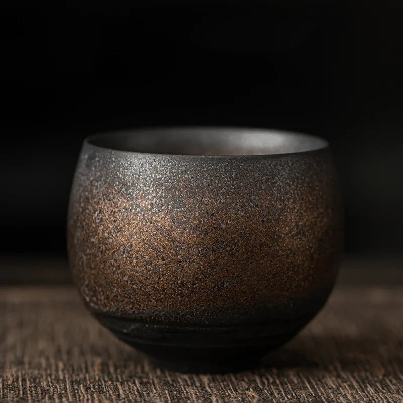 Brown ceramic cup on a wooden surface with a dark background