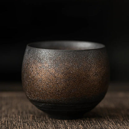 Brown ceramic cup on a wooden surface with a dark background