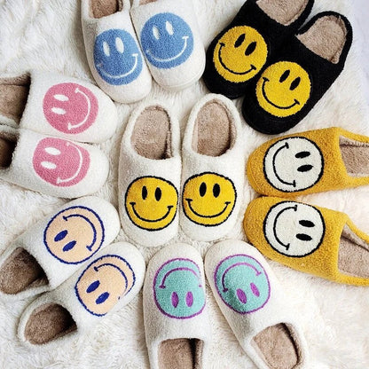 Smiley face slippers in various colors arranged on a soft surface.