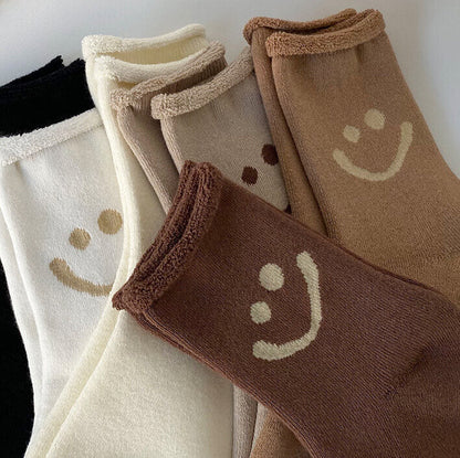 Set of socks with smiley face designs in various colors.
