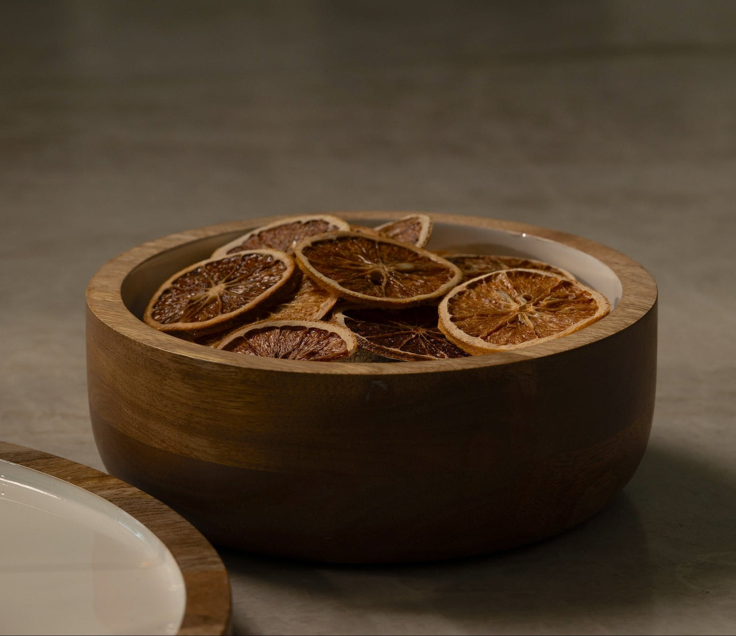 Wooden bowl with dried orange slices on a dark background
