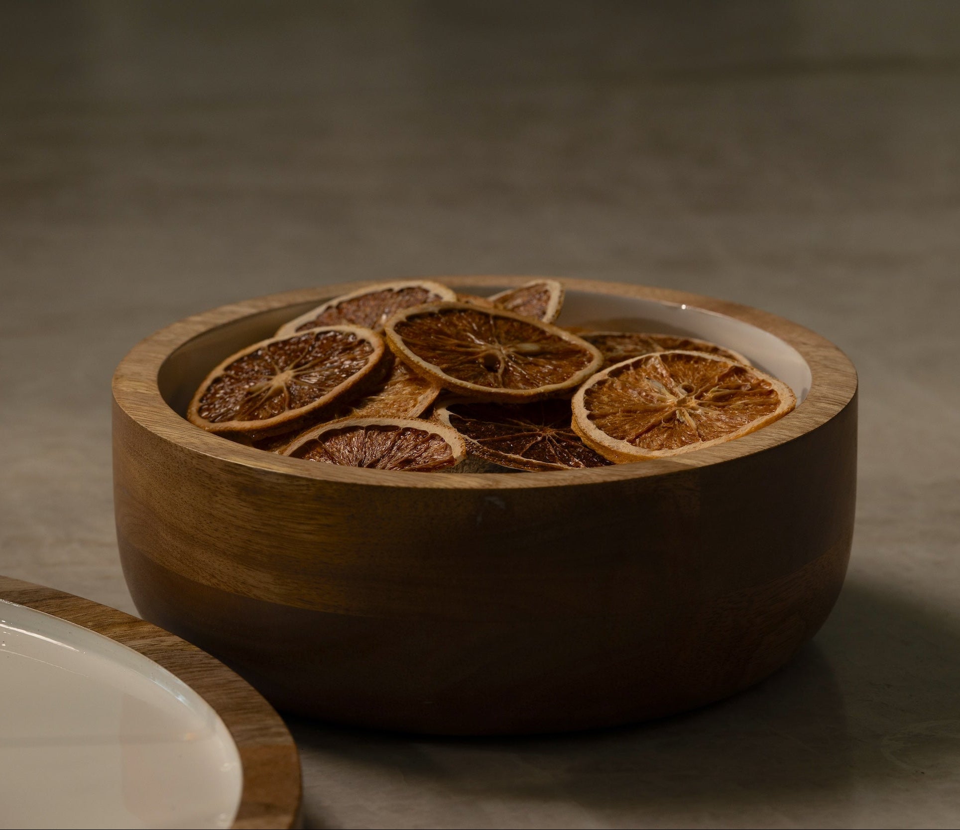Wooden bowl with dried orange slices on a dark background