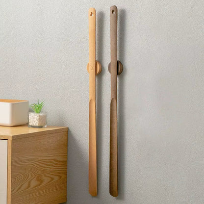 Two wooden sticks with circular ends on a light gray wall.