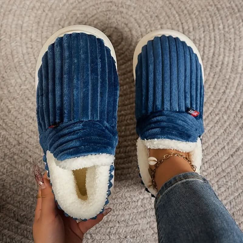 Blue slippers with white soles on a textured surface