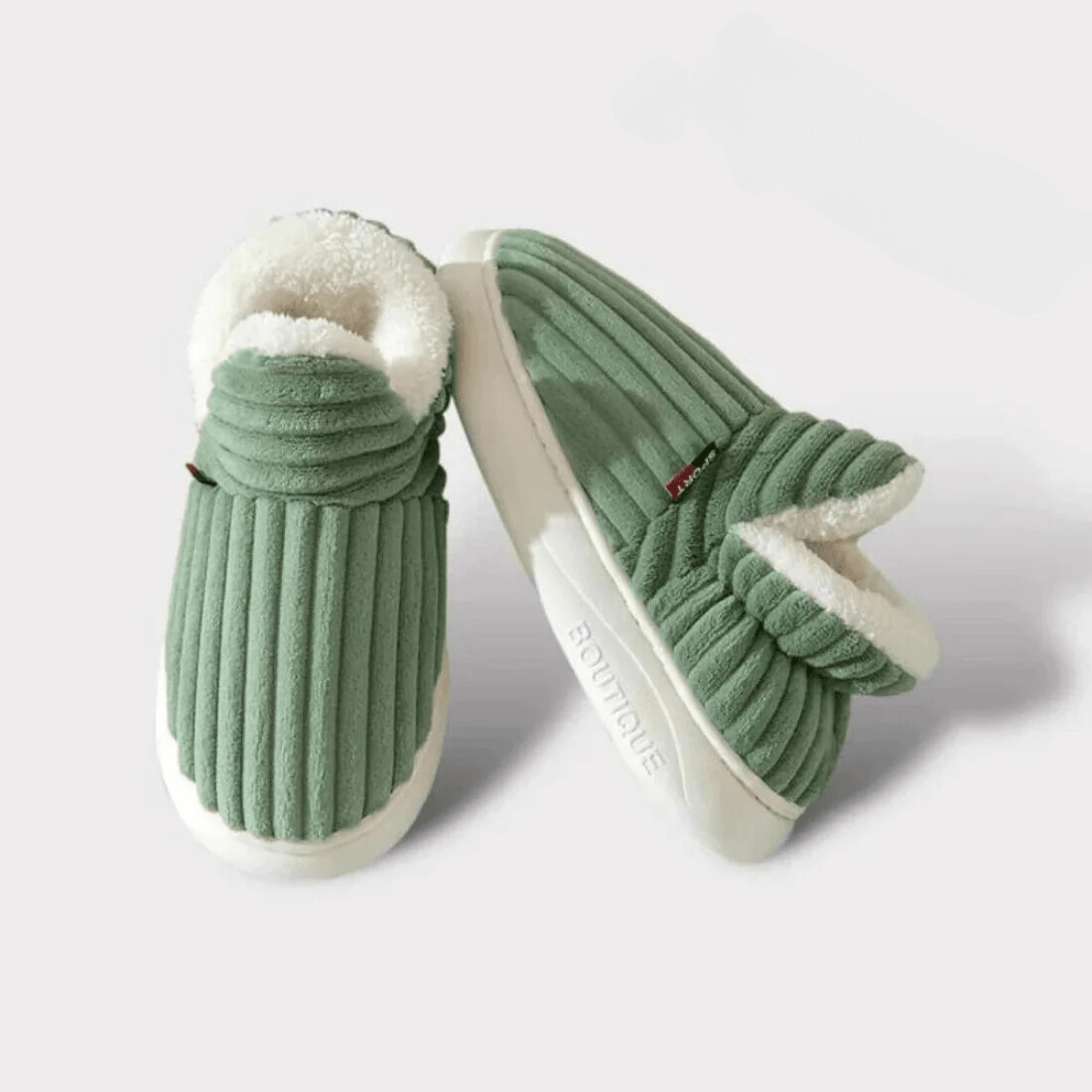 Green slippers with white soles on a light gray background