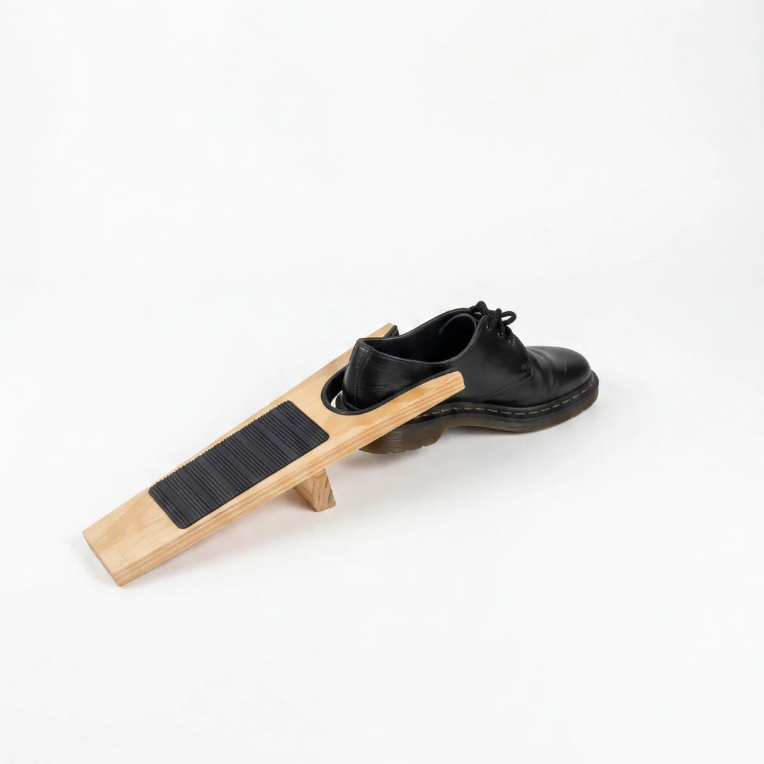 Josh & Tate - HeelHook™ Wooden Boot Jack - Black leather shoe on a wooden block with a white background