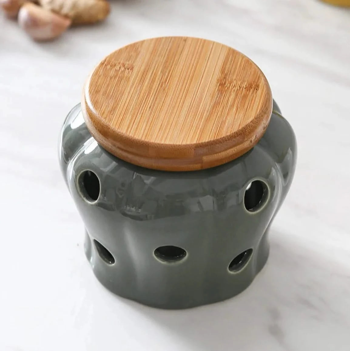 Gray ceramic jar with a wooden lid on a light background