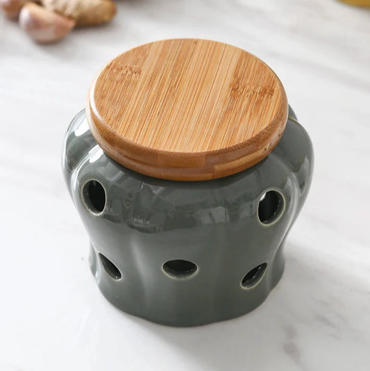 Gray ceramic jar with a wooden lid on a light background