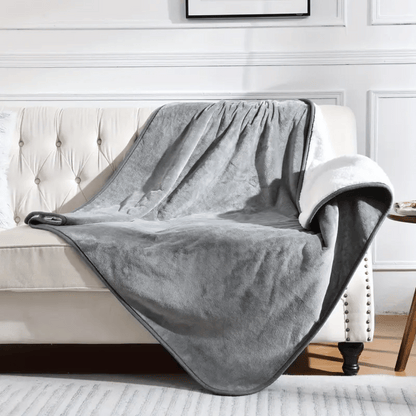 Gray blanket draped over a white sofa in a living room setting.