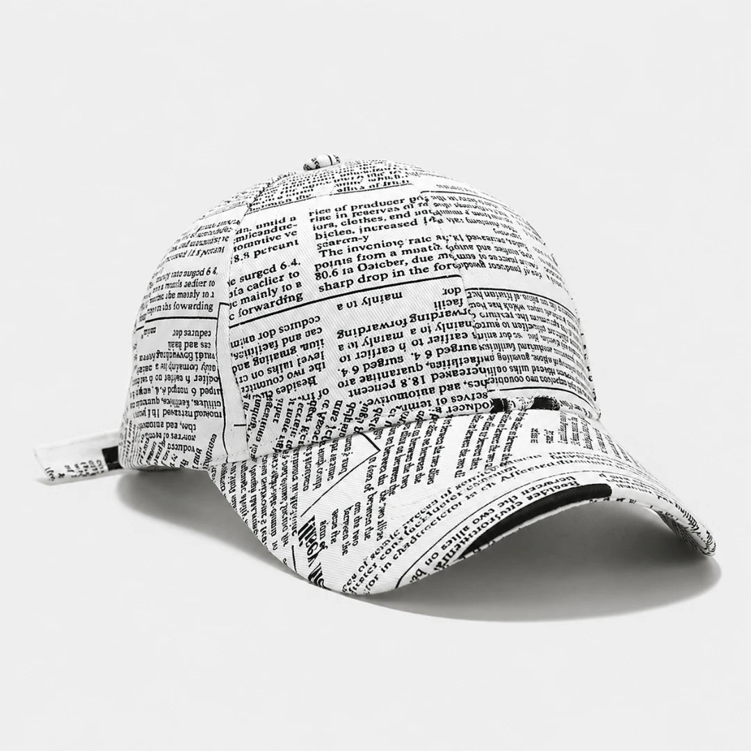 Josh & Tate - InkPress™ Newsprint Cap - A baseball cap printed with dense black text resembling a dictionary or encyclopedia page, shown on a clean white background.