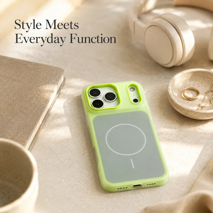 Josh & Tate - JellyHalo™ MagSafe iPhone Case - A light green phone case with a gray magnetic wireless charging panel, shown on a phone in a styled flat-lay setting with headphones, a cup, and a notebook.