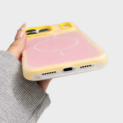 Josh & Tate - JellyHalo™ MagSafe iPhone Case - A hand holding a translucent phone case with a pink back panel and yellow bumper edges, shown against a clean light gray background.