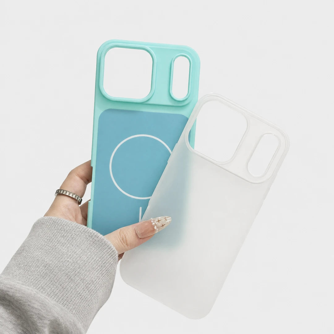Josh & Tate - JellyHalo™ MagSafe iPhone Case - A hand wearing a gray long-sleeve shirt holds two phone cases against a clean white background. One case is a translucent aqua blue with a solid blue magnetic strip and white circular logo, while the other is a semi-translucent frosted white case.