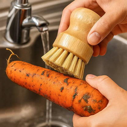 Person cleaning a carrot with a wooden brush under running water.