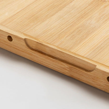 Close-up of a wooden cutting board with a handle on a light background