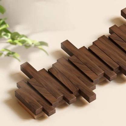 Wooden coasters arranged on a light surface with a plant in the background