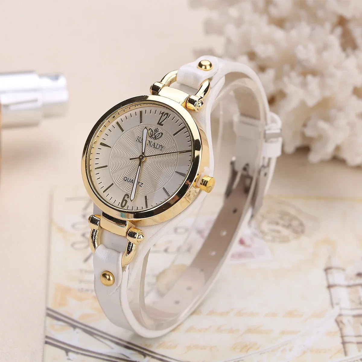 White watch with gold accents on a textured surface
